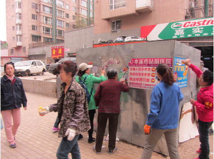 党员志愿者清理小广告，助力创建文明社区